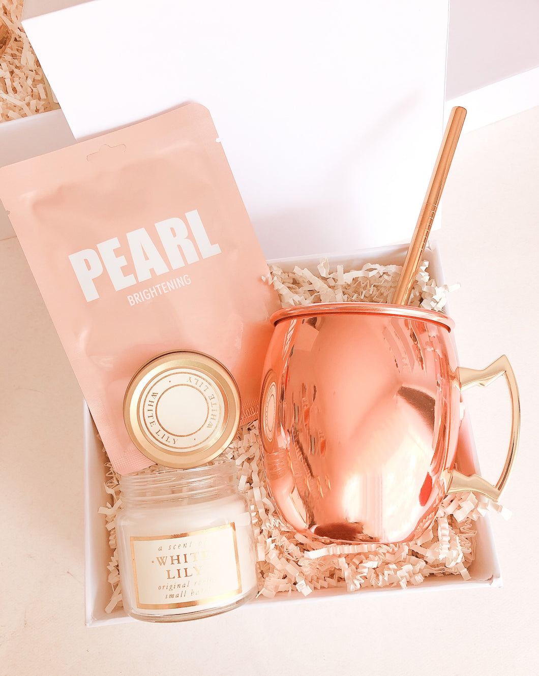 Esta Gift Box inspirada en mamá incluye:  • Mascarilla facial Pearl • Vela aromática White Lily • Taza rose gold • Caja Premium • Listón • Tarjeta de dedicatoria