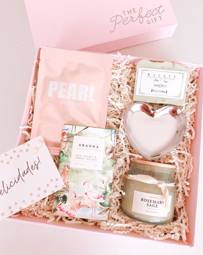 Esta Gift Box inspirada en mamá incluye:  • Joyero de corazón plata • Vela aromática Rosemary sage • Jabón artesanal de Eucalipto • Mascarilla facial  Pearl • Chocolate artesanal y vegano Cacao + Arroz inflado • Caja Premium • Listón • Tarjeta de dedicatoria
