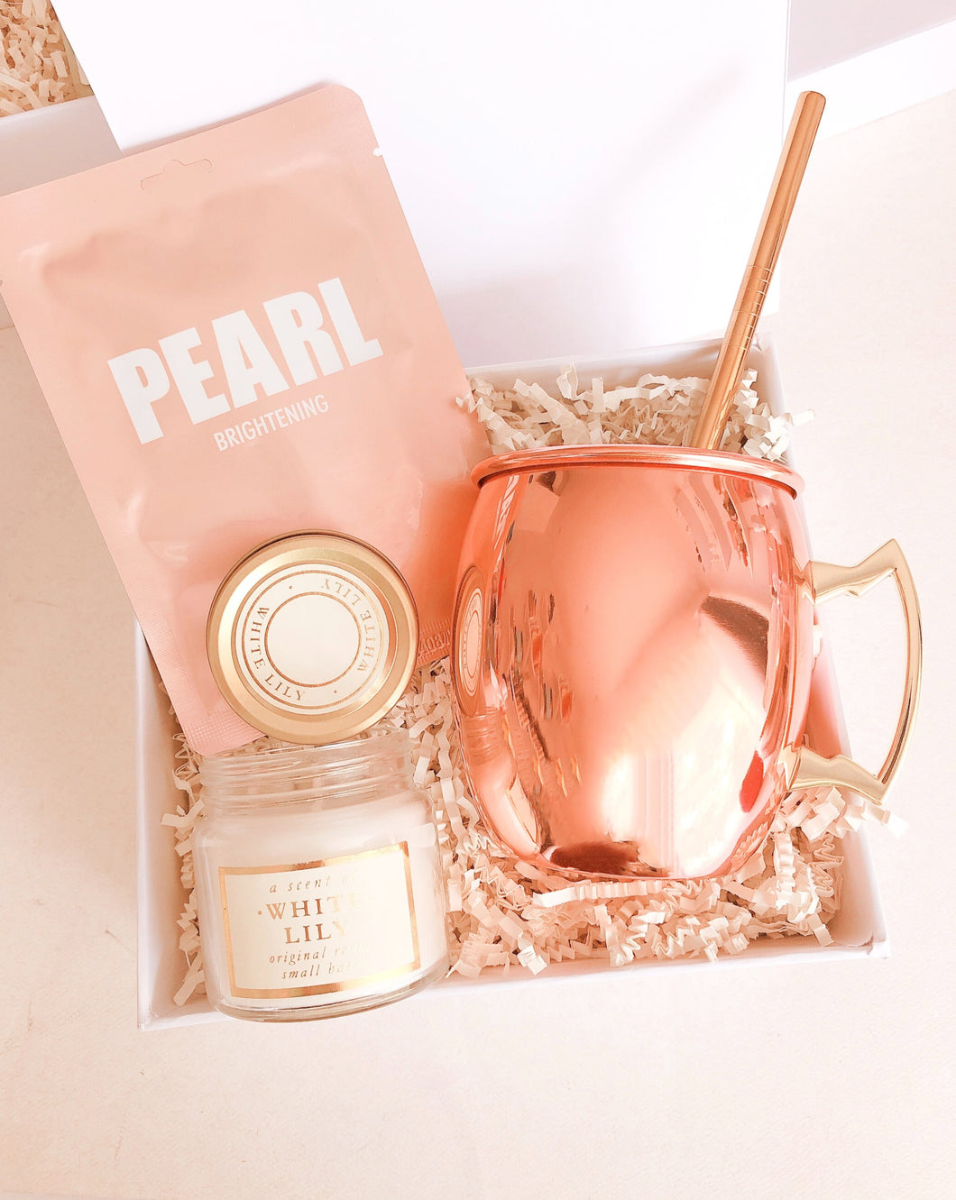 Esta Gift Box incluye:  • Mascarilla facial Pearl • Vela aromática White Lily • Taza rose gold • Caja Premium • Listón • Tarjeta de dedicatoria