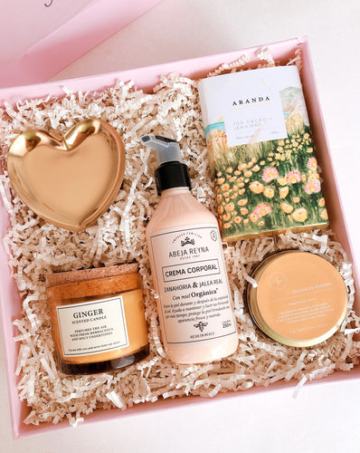 Esta Gift Box incluye:  • Joyero de Corazón dorado • Vela aromática Ginger • Crema corporal de Zanahoria + Jalea Real con FPS 50  • Tisana Delicia de Guayaba • Chocolate artesanal y vegano de Cacao + Jengibre • Caja Premium • Listón • Tarjeta de dedicatoria